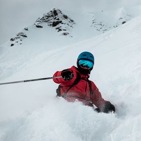 Ein Skifahrer in Zermatt carvt geschickt durch den Tiefschnee und hinterlässt kunstvolle Spuren im Pulverschnee.