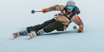 Ein Skifahrer auf Van Deer Skis nimmt eine scharfe Kurve auf der verschneiten Piste
