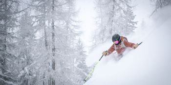 Ein Skifahrer in Zermatt stürzt sich wagemutig in eine steile Abfahrt und lässt den Schnee aufwirbeln.