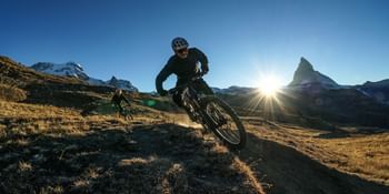 Ein actionreicher Downhill-Ride in Zermatt lässt die Herzen der Mountainbike-Enthusiasten höher schlagen, umgeben von alpiner Kulisse.