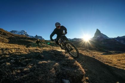 Ein actionreicher Downhill-Ride in Zermatt lässt die Herzen der Mountainbike-Enthusiasten höher schlagen, umgeben von alpiner Kulisse.
