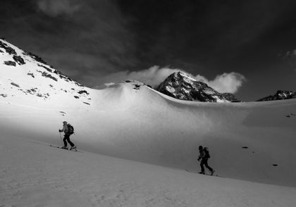 Ein Skitourengeher steigt durch tiefen Pulverschnee in Zermatt und hinterlässt seine Spuren in der makellosen Schneelandschaft.