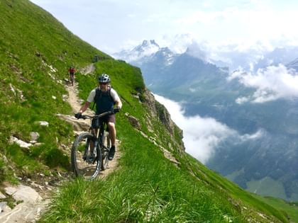 Radfahrer erleben die Freiheit und das Abenteuer der Bergwelt in Zermatt, während sie auf anspruchsvollen Trails unterwegs sind.