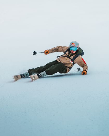 A skier on Van Deer Skis takes a sharp turn on the snowy piste.
